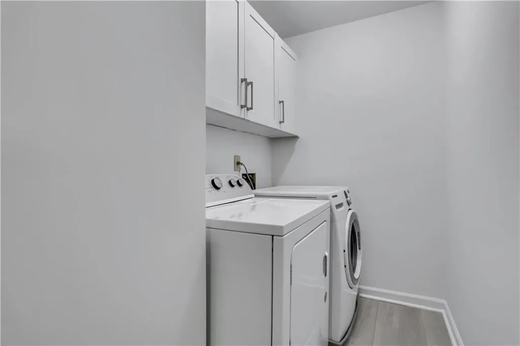 Washroom featuring  cabinets, and washing machine and clothes dryer Washroom featuring  cabinets, and washing machine and clothes dryer