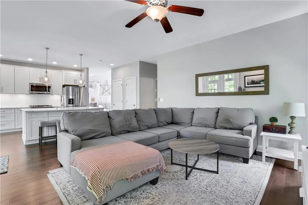 Living room with ceiling fan, sink, and dark hardwood / wood-style flooring Living room with ceiling fan, sink, and dark hardwood / wood-style flooring