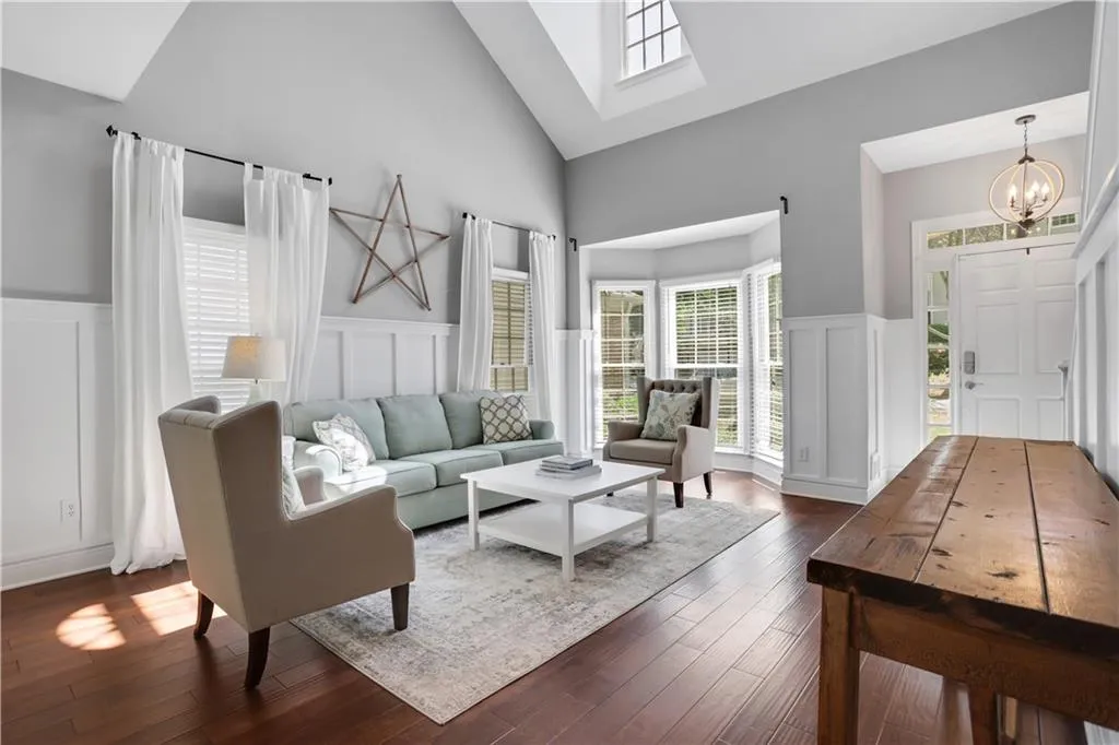 Living room with dark hardwood / wood-style floors, high vaulted ceiling, and an inviting chandelier Living room with dark hardwood / wood-style floors, high vaulted ceiling, and an inviting chandelier