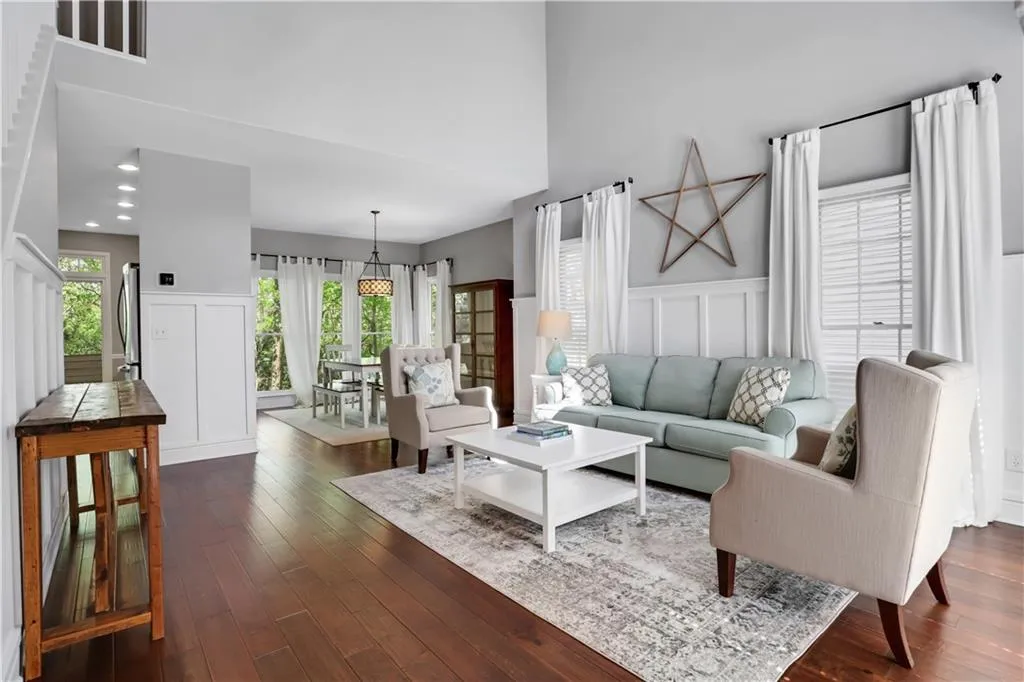 Living room featuring dark hardwood / wood-style flooring and a towering ceiling Living room featuring dark hardwood / wood-style flooring and a towering ceiling