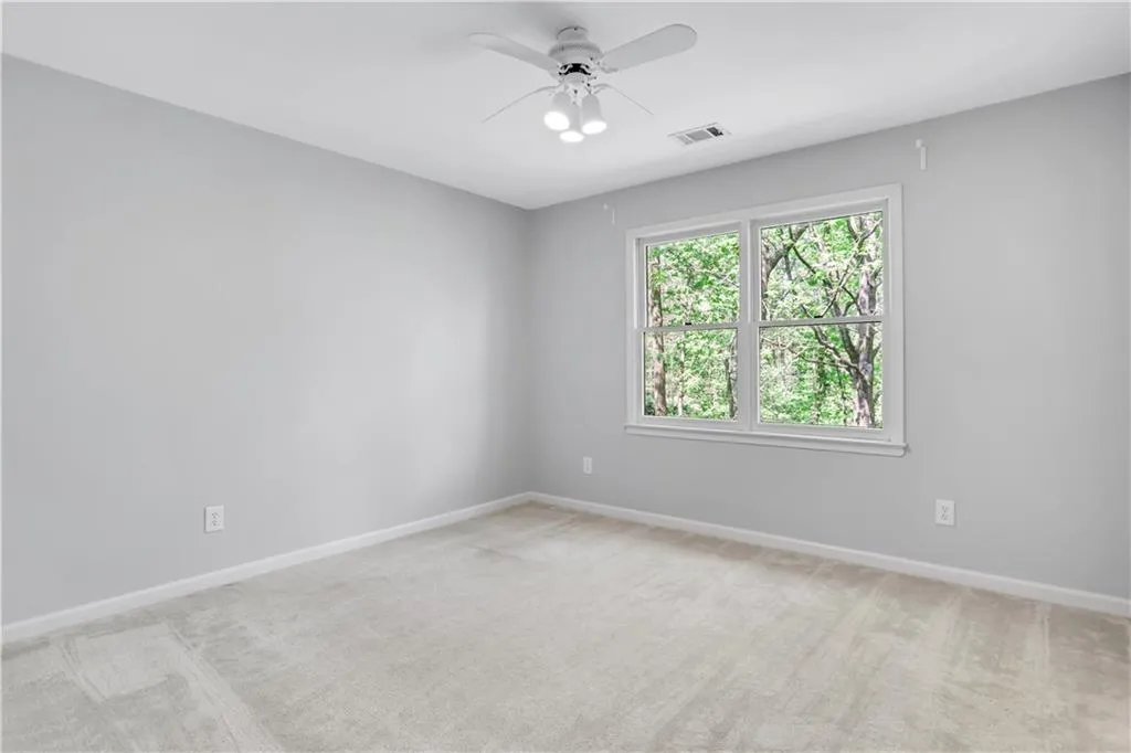 Carpeted empty room featuring ceiling fan Carpeted empty room featuring ceiling fan