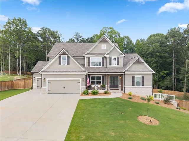 Craftsman-style exterior with a covered porch, two-car garage, and a concrete driveway