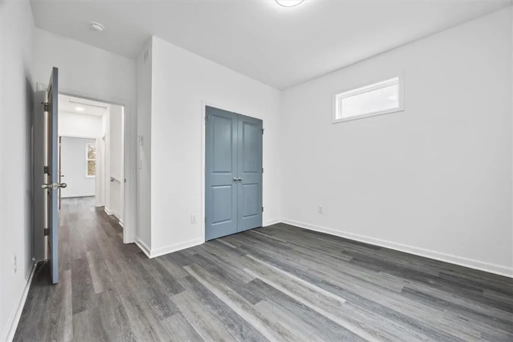 Unfurnished bedroom featuring dark wood-type flooring
