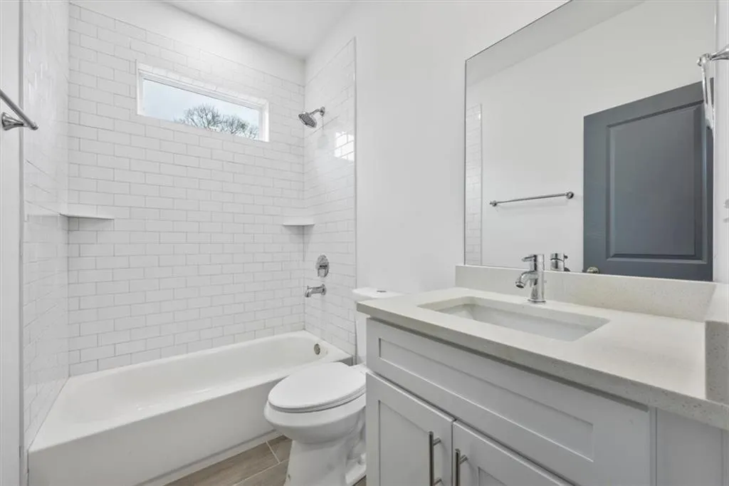 Full bathroom featuring toilet, tiled shower / bath, and vanity