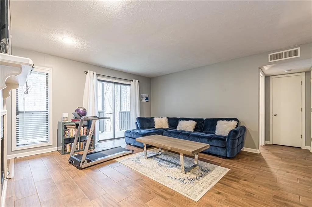Living room with a textured ceiling and light hardwood / wood-style floors