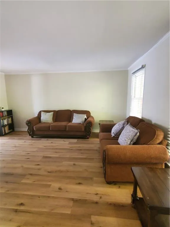 Living area featuring ornamental molding and wood finished floors