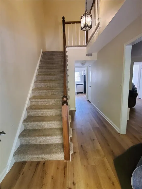 Stairs with wood finished floors and a high ceiling