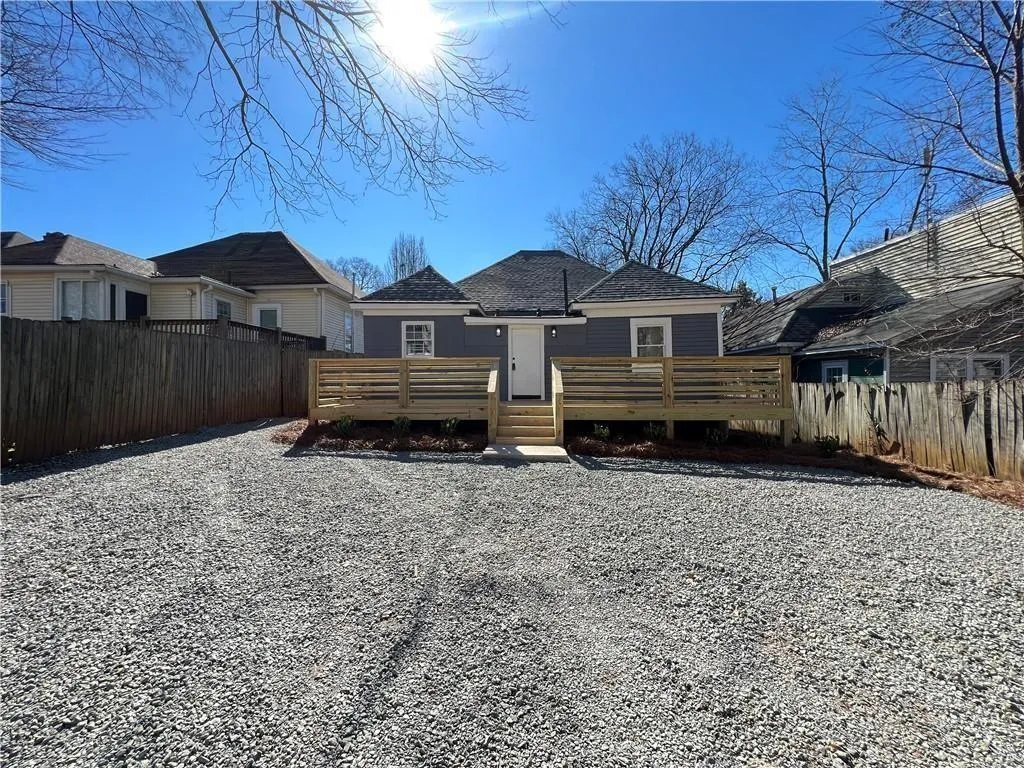 Rear view of property with fence and a wooden deck