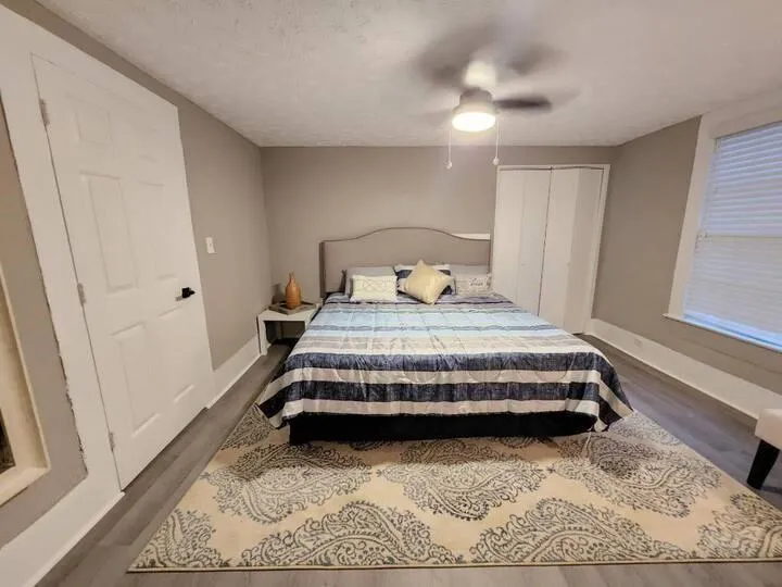 Bedroom with baseboards, a textured ceiling, ceiling fan, and dark wood-style floors