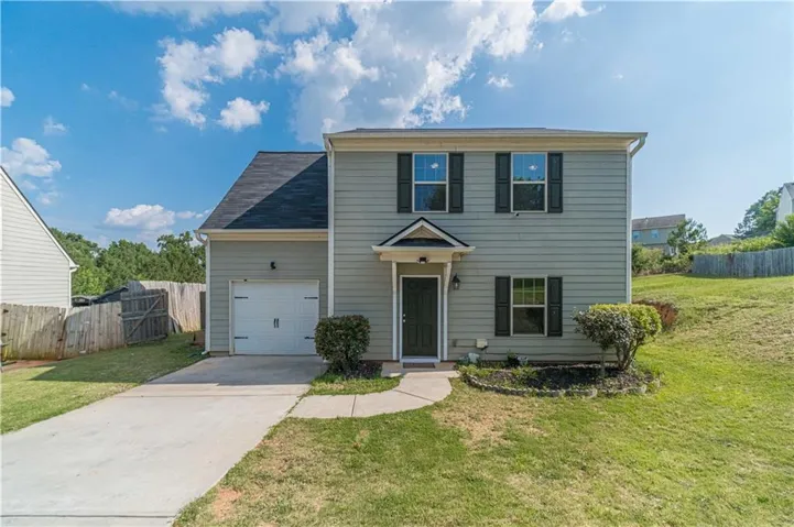 Two-story residence featuring siding exterior, a front entry garage, and a concrete driveway