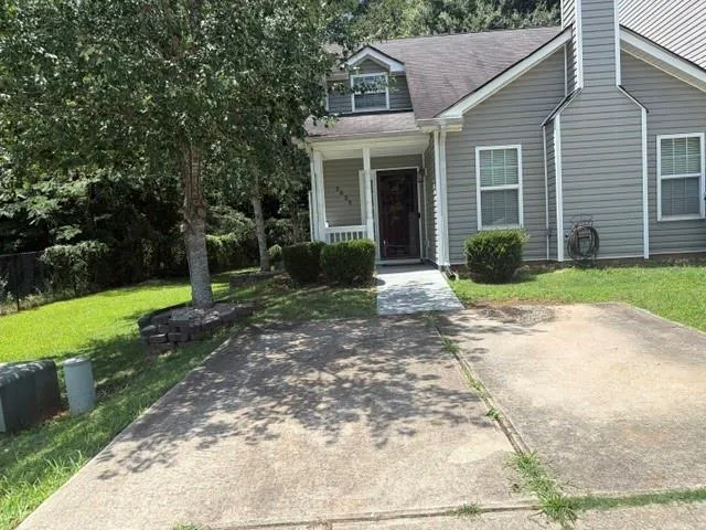 Gray siding exterior with white window frames and a prominent front porch with white columns