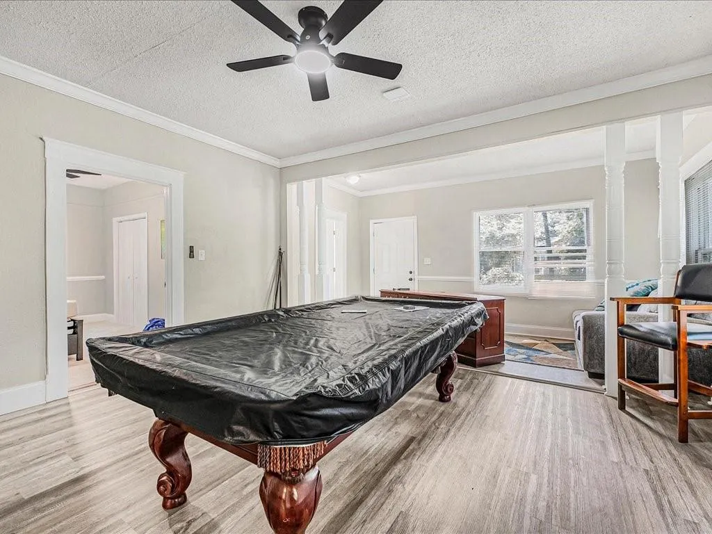 Game room with billiards table, wood finished floors, crown molding, a textured ceiling, and a ceiling fan