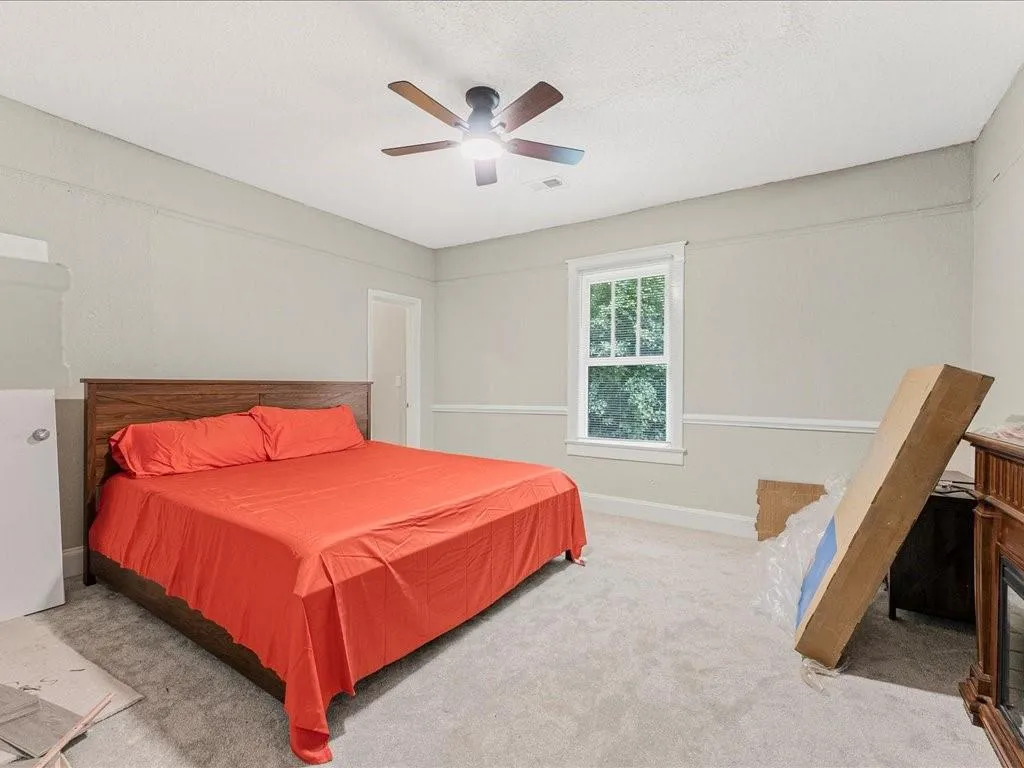 Bedroom with carpet, ceiling fan, and a textured ceiling