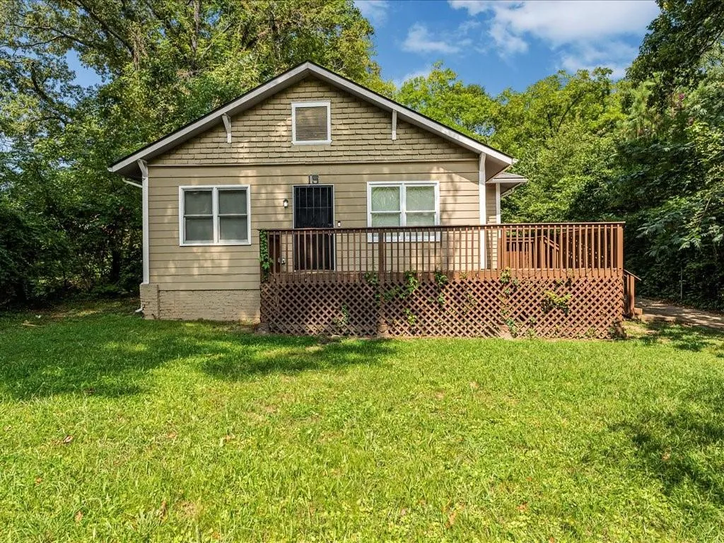 Rear view of property featuring a yard and a deck