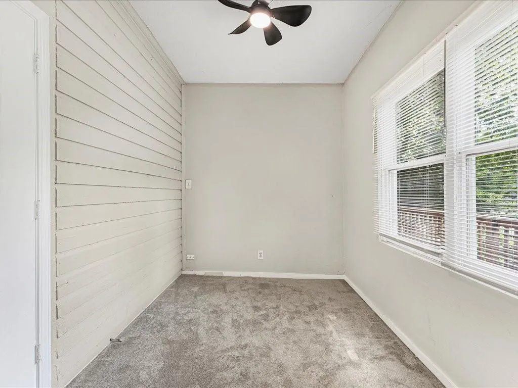 Empty room with light carpet and a ceiling fan