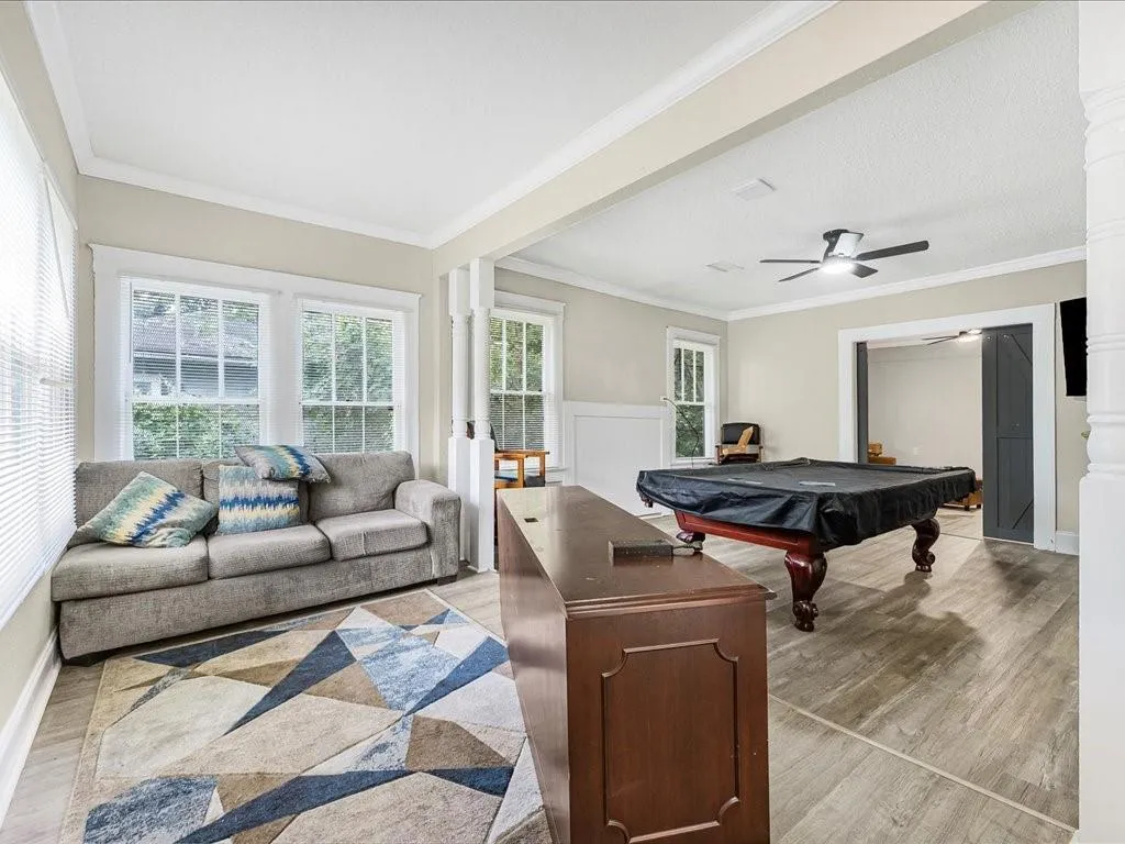Rec room with crown molding, pool table, light wood-type flooring, and ceiling fan