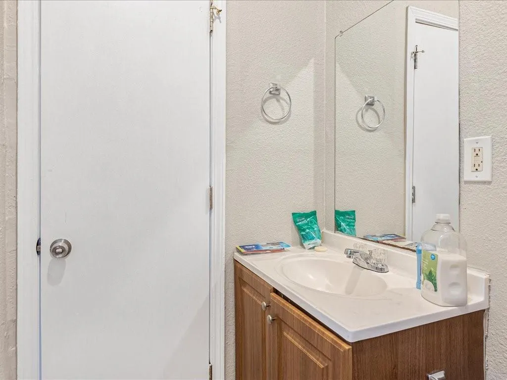 Bathroom featuring a textured wall and vanity