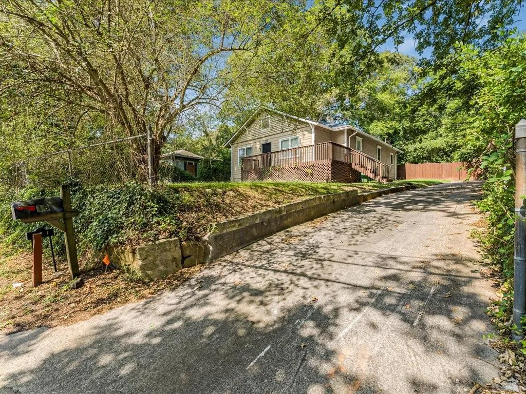 View of home's exterior with a wooden deck and driveway