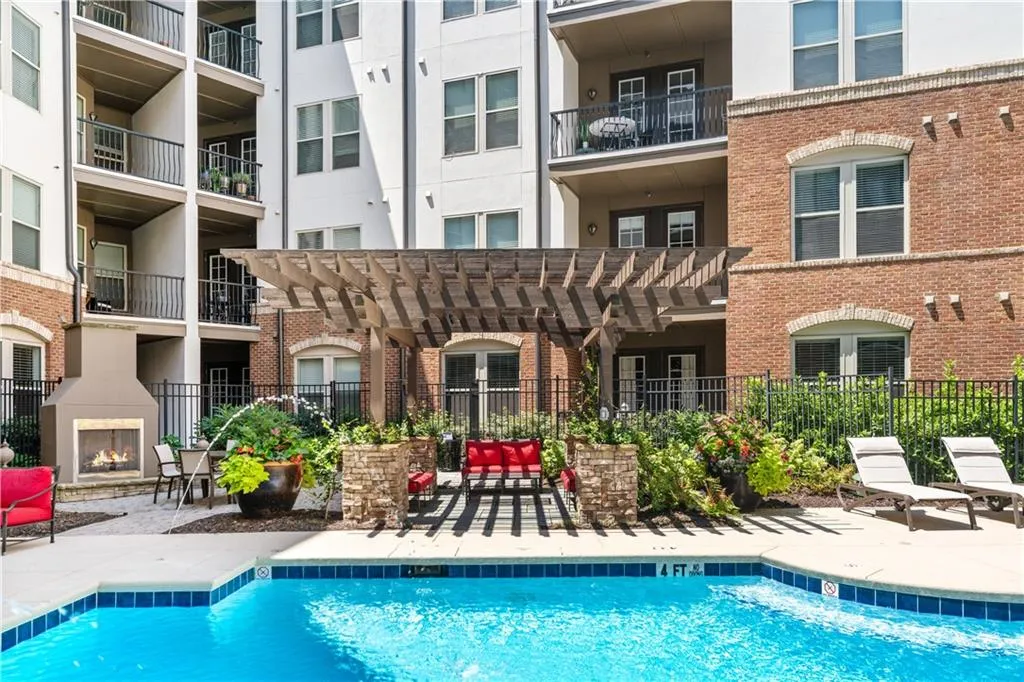 Community pool with a lit fireplace and a patio