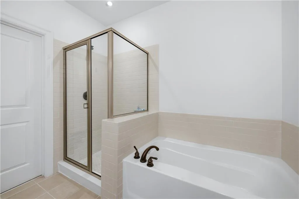 Full bath with a bath, a stall shower, light tile patterned floors, and recessed lighting