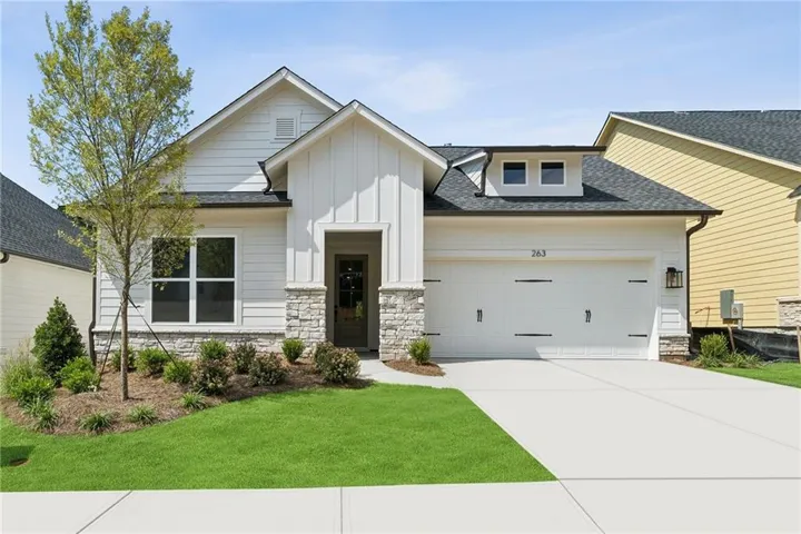 Contemporary exterior with white horizontal siding, board and batten accents, and stone detailing