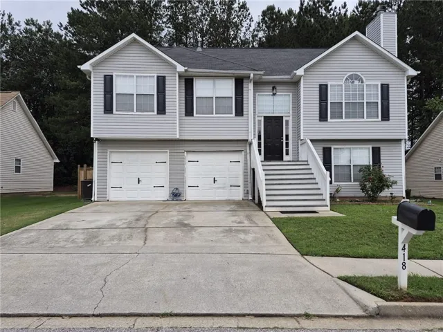 Gray siding exterior with white trim, featuring a prominent front staircase leading to the main entry