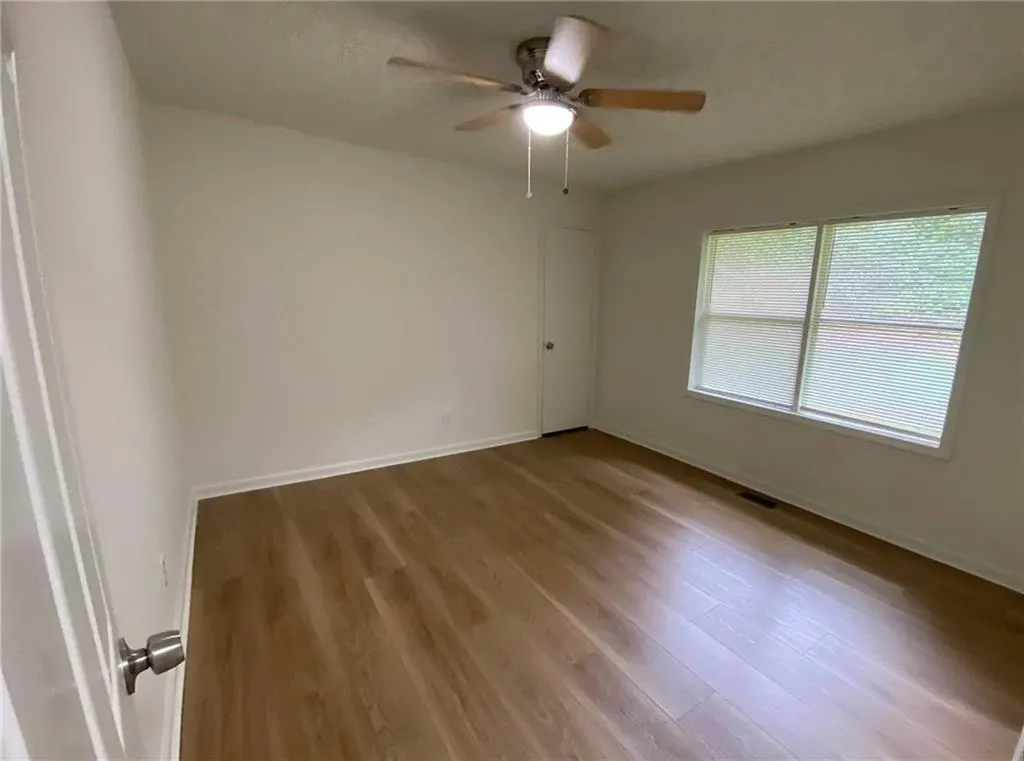 Unfurnished room featuring wood finished floors and ceiling fan
