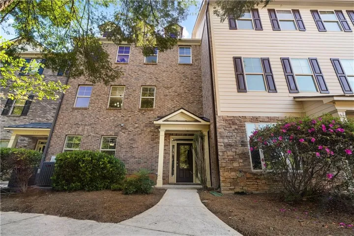 Brick and siding exterior with stone accents, covered entry, and established landscaping