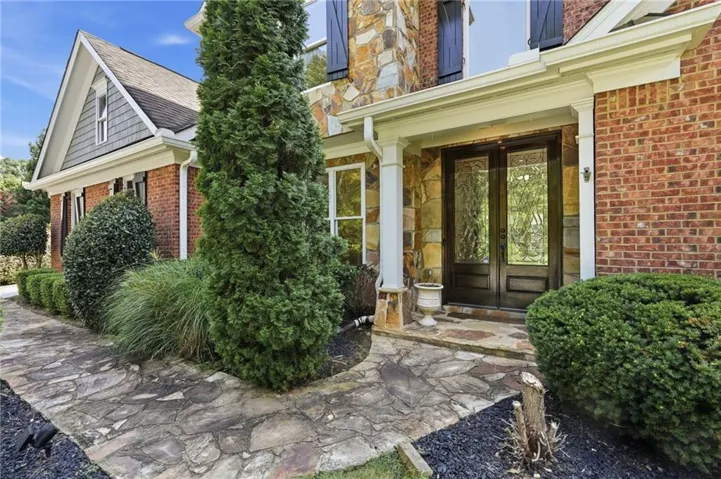 Stone pathway leading to a double-door entry with decorative glass