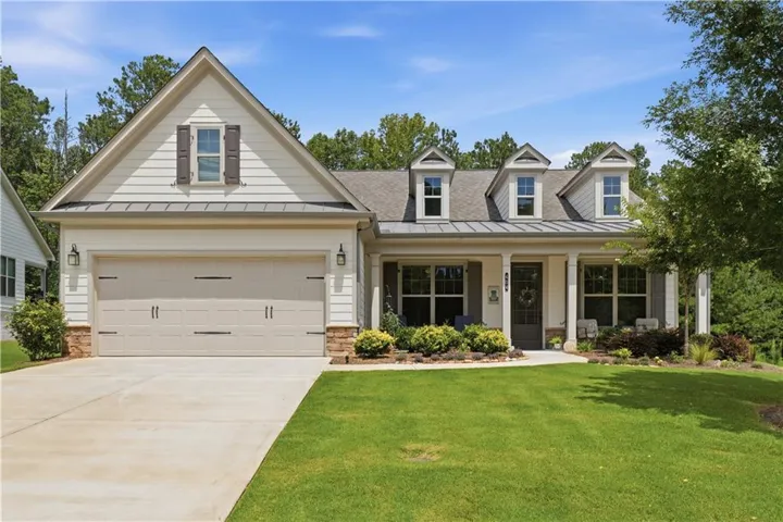 Gable roofline with dormer windows and a covered front porch featuring stone accents