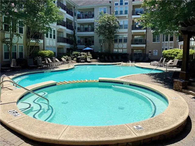 Resort-style outdoor pool with integrated spa and surrounding paver decking