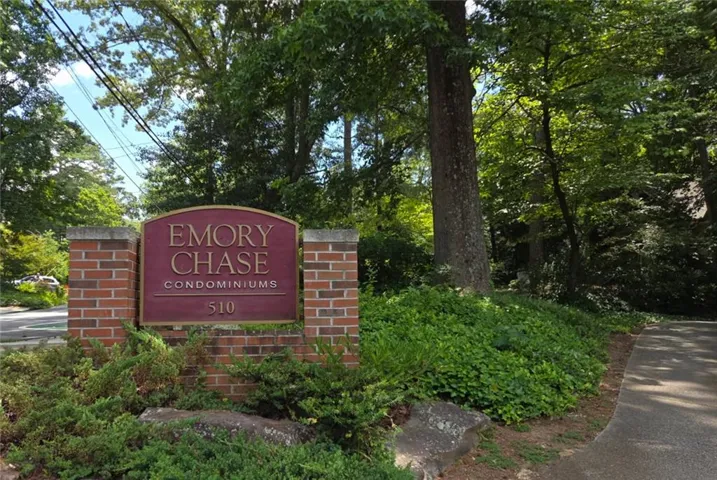 Brick entrance monument featuring a bronze-finish sign with "Emory Chase Condominiums" and address number "510"