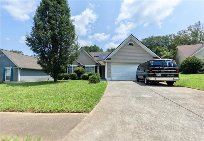Single-story residence featuring light-colored siding, a prominent front-facing gable, and a two-car garage