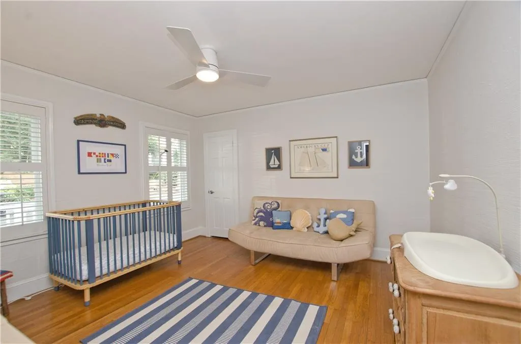 This secondary bedroom on the main floor  has plantation shutters  and hardwood floors.