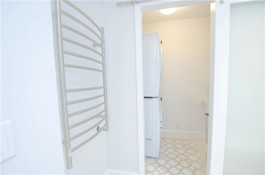 The primary bath opens to the convenient laundry area.   The primary bath features a heated towel bar.