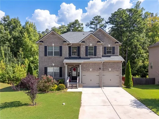 Brick exterior with a gabled roofline, front porch entry, and a two-car garage