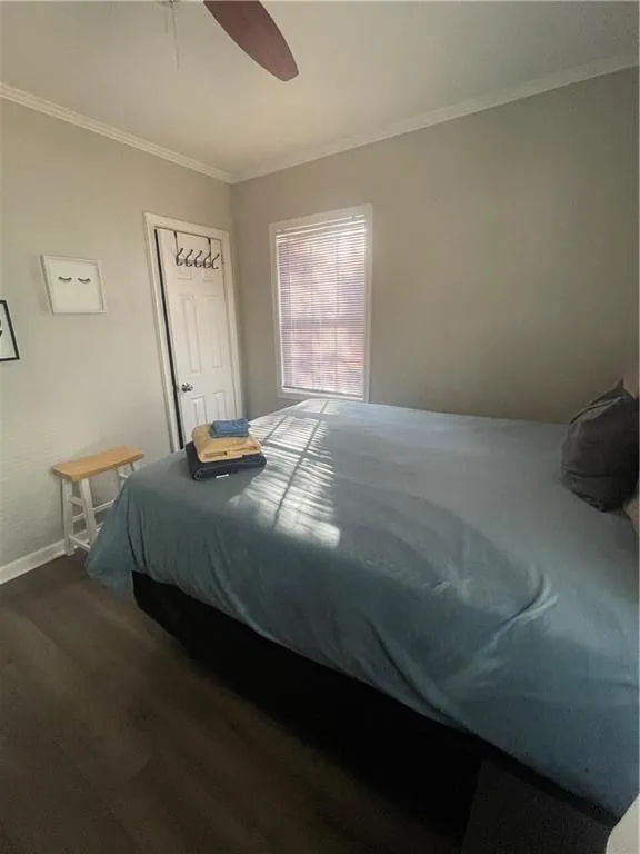 Bedroom with hardwood / wood-style floors, ceiling fan, and crown molding