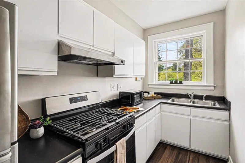Kitchen Featuring White Cabinetry, Stainless Steel Appliances, & Ample Prep Space