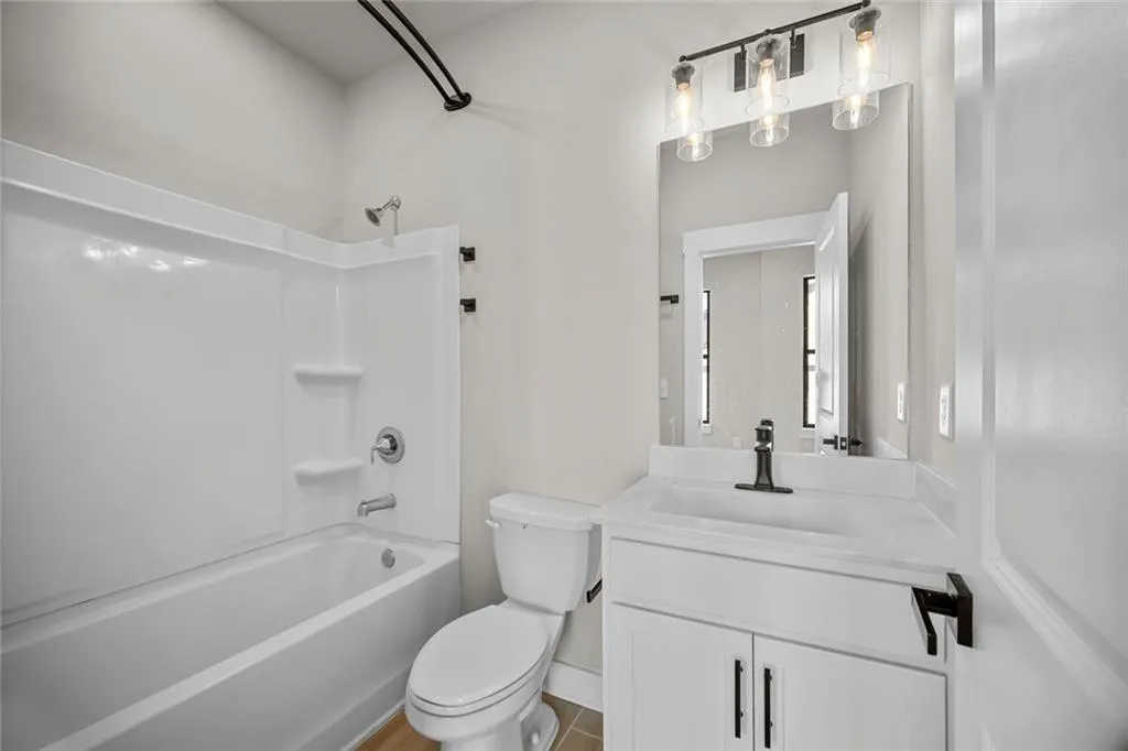 White vanity with integrated sink, rectangular mirror, and matte black faucet