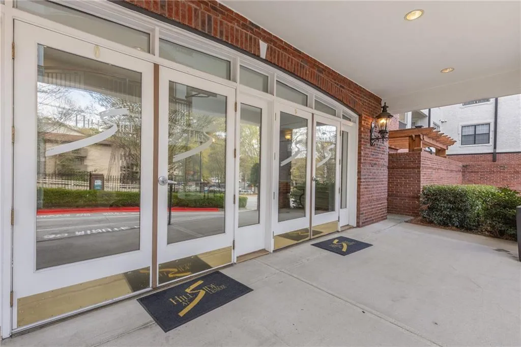 Property entrance with brick siding and a patio