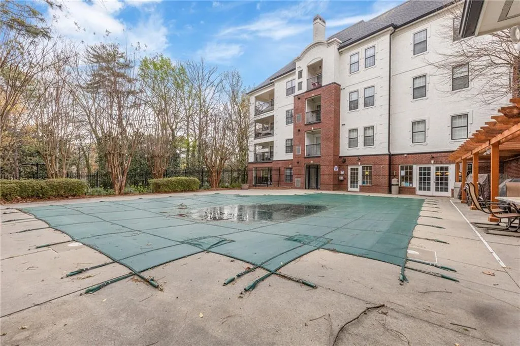 View of swimming pool featuring a covered pool, patio surround, and a pergola
