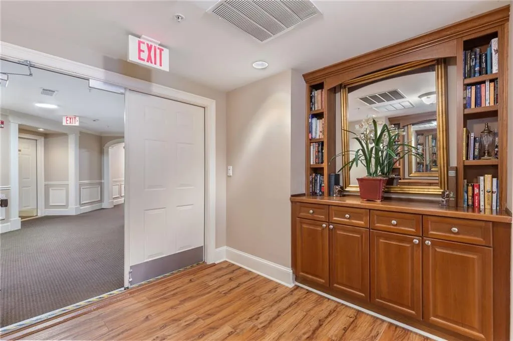 Hall with arched walkways, light wood-style flooring, and recessed lighting