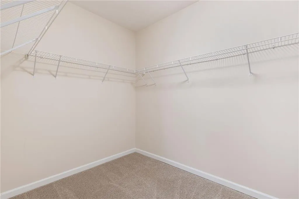 Walk in closet with light carpet