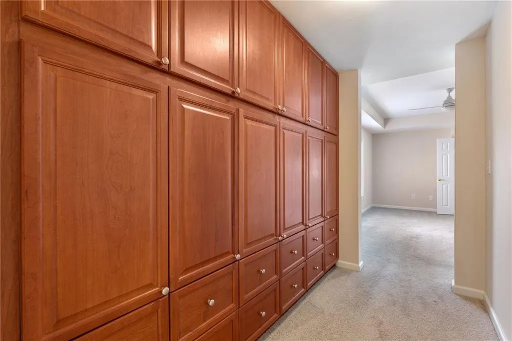 Hall featuring baseboards and light colored carpet