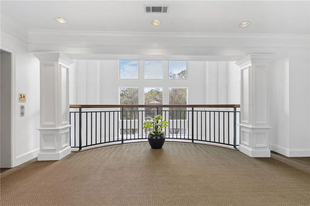 Hall with ornate columns, crown molding, recessed lighting, and carpet flooring