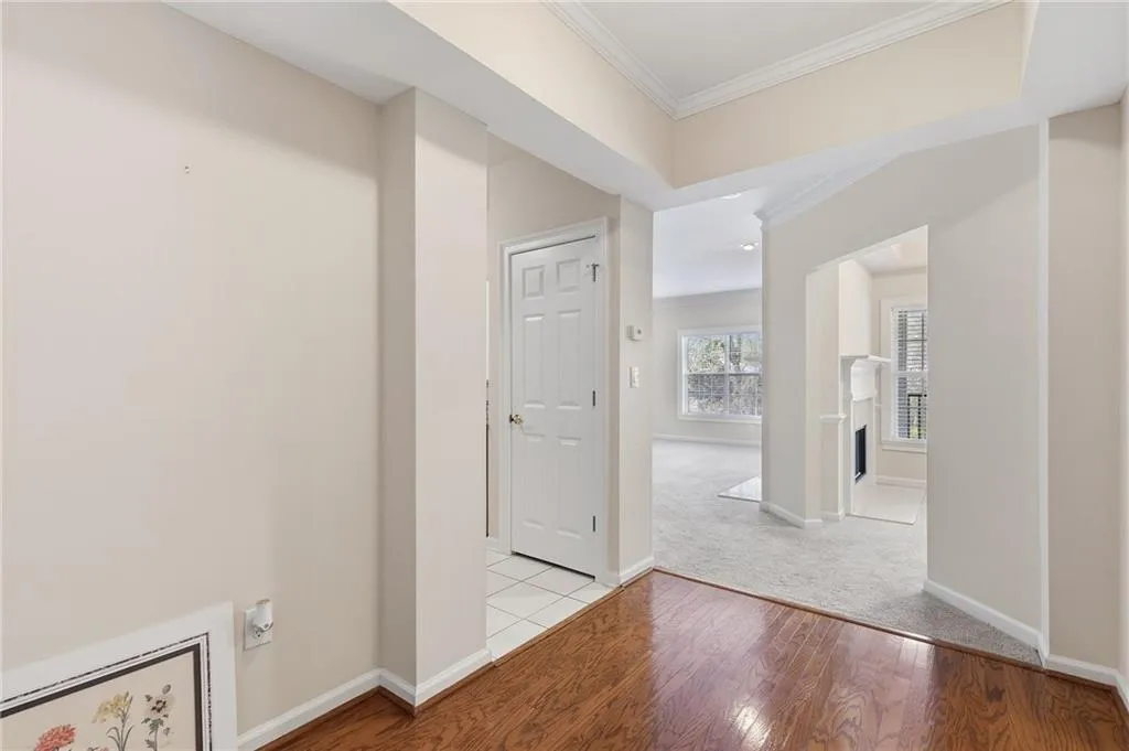 Hall with light wood-style floors and ornamental molding