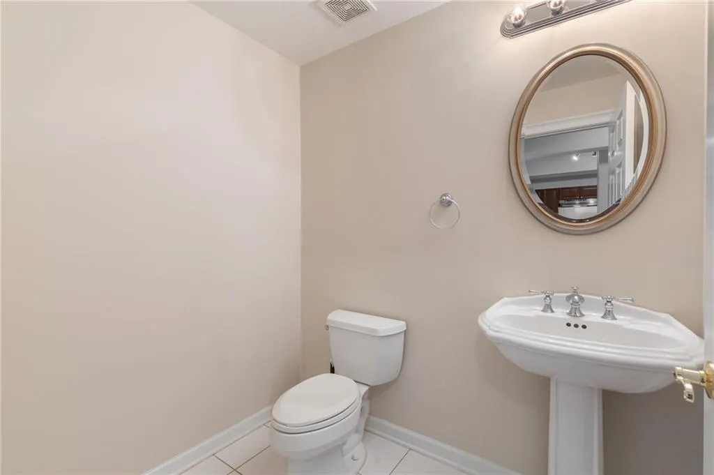 Half bathroom with toilet and light tile patterned flooring