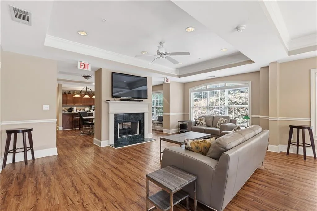 Living area with ornamental molding, wood finished floors, a fireplace, ceiling fan, and recessed lighting