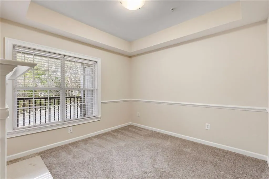 Empty room with a tray ceiling and light carpet