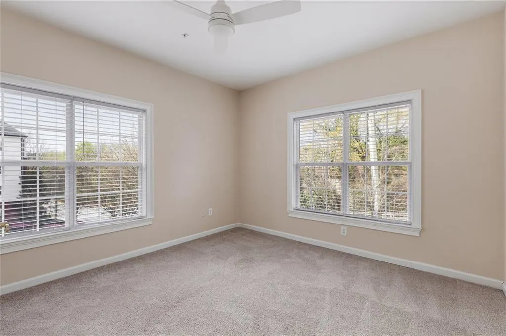 Unfurnished room with light colored carpet and ceiling fan